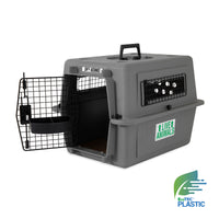 The gray Petmate Sky Kennel pet carrier has a wire door, side ventilation holes, a Live Animals label, and an EcoTEC Plastic logo. Designed for travel, it features a top handle and complies with airline cargo specs.