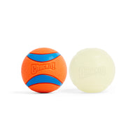 Two Petmate Chuckit! Day & Night Ultra Ball Large dog balls—one orange with blue stripes and texture, the other smooth and pale greenish-white (likely glow in the dark)—are shown on a white background.