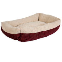 The Aspen Pet Self-Warming Bolster Mat by Aspen Pet is a plush, rectangular pet bed with high sides, featuring a deep red corduroy exterior and cream-colored fleece interior, ensuring a cozy resting space for pets.