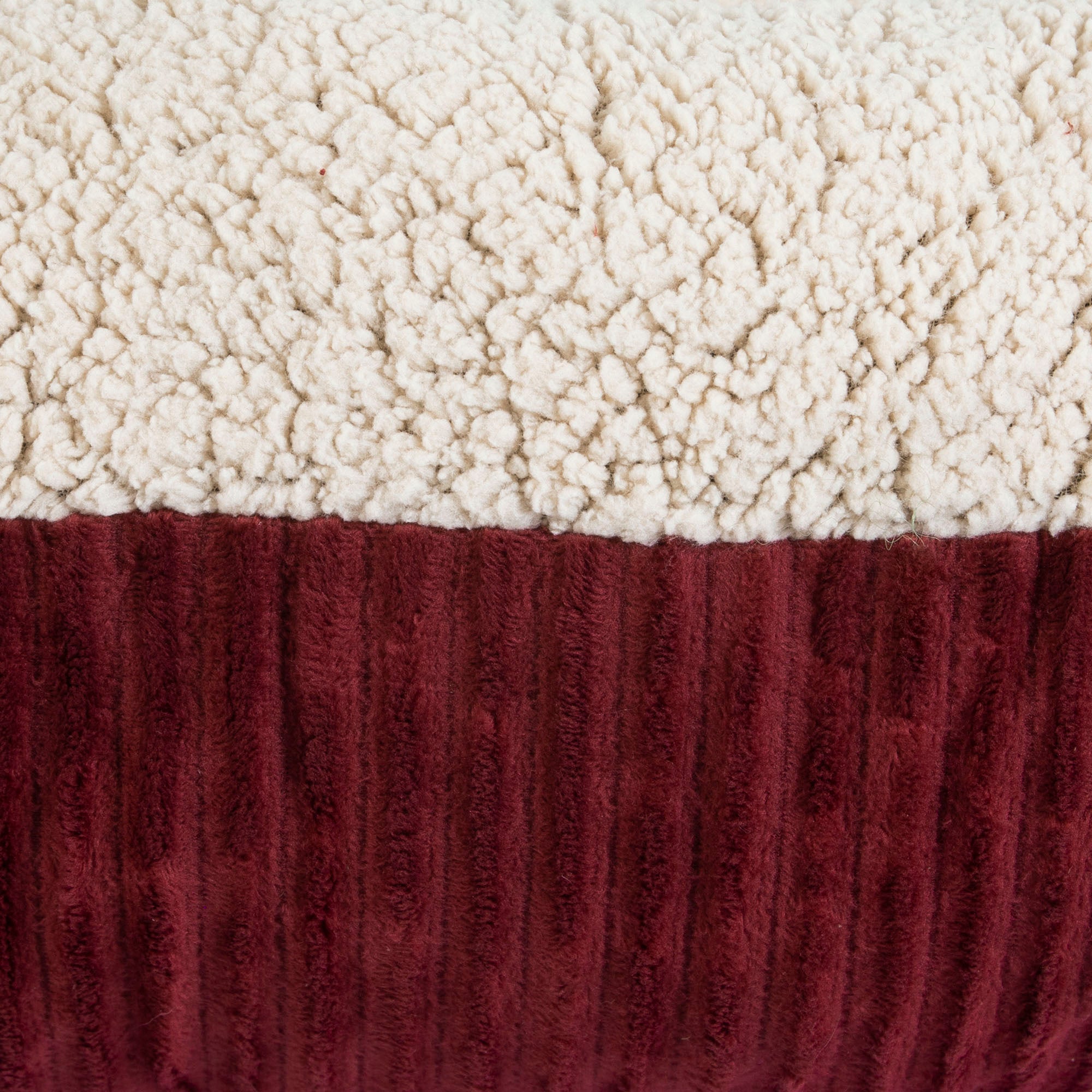 Close-up of the Aspen Pet Self-Warming Bolster Mat, featuring a plush textured fabric ideal for kennel mats. The top is cream-colored, resembling soft fleece, and the bottom is burgundy with a ribbed pattern.