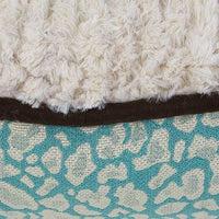 The Petmate Two-Sided Fashion Dog Pillow Bed features a close-up fabric detail: white fluffy texture atop a dark brown strip, with turquoise fabric showcasing a light beige leopard print below, all in a cozy, washable design.